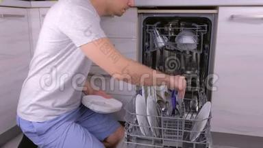 面目全非的人把一个白色的脏盘子放进洗碗机，然后在厨房里运行。